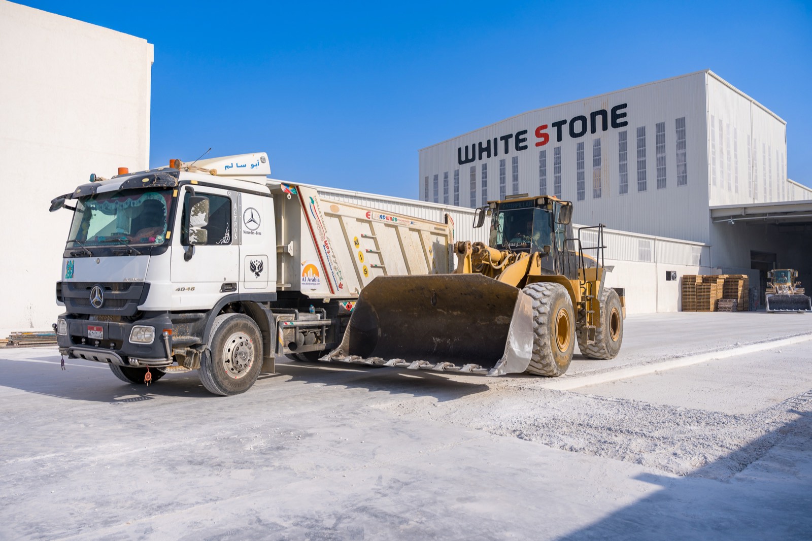 Truck and wheel loader in front of the White Stone facility, Ain Sokhna