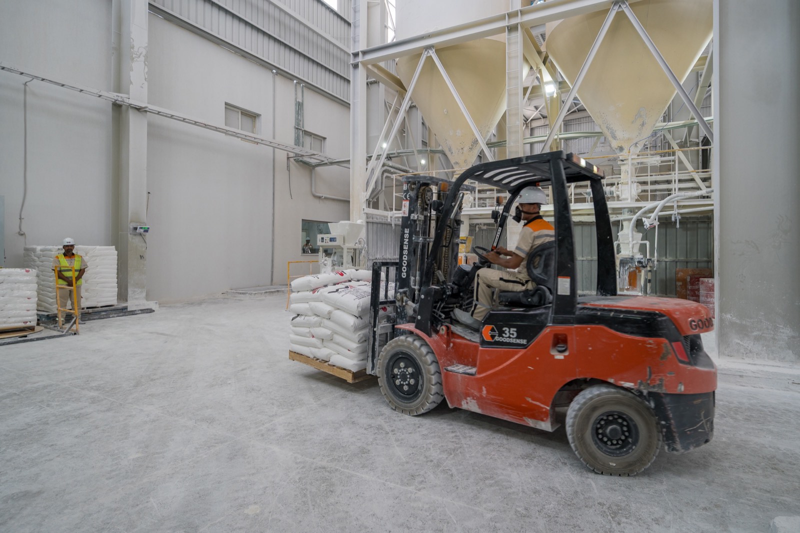 Forklift carrying palletized bags from the packing stations