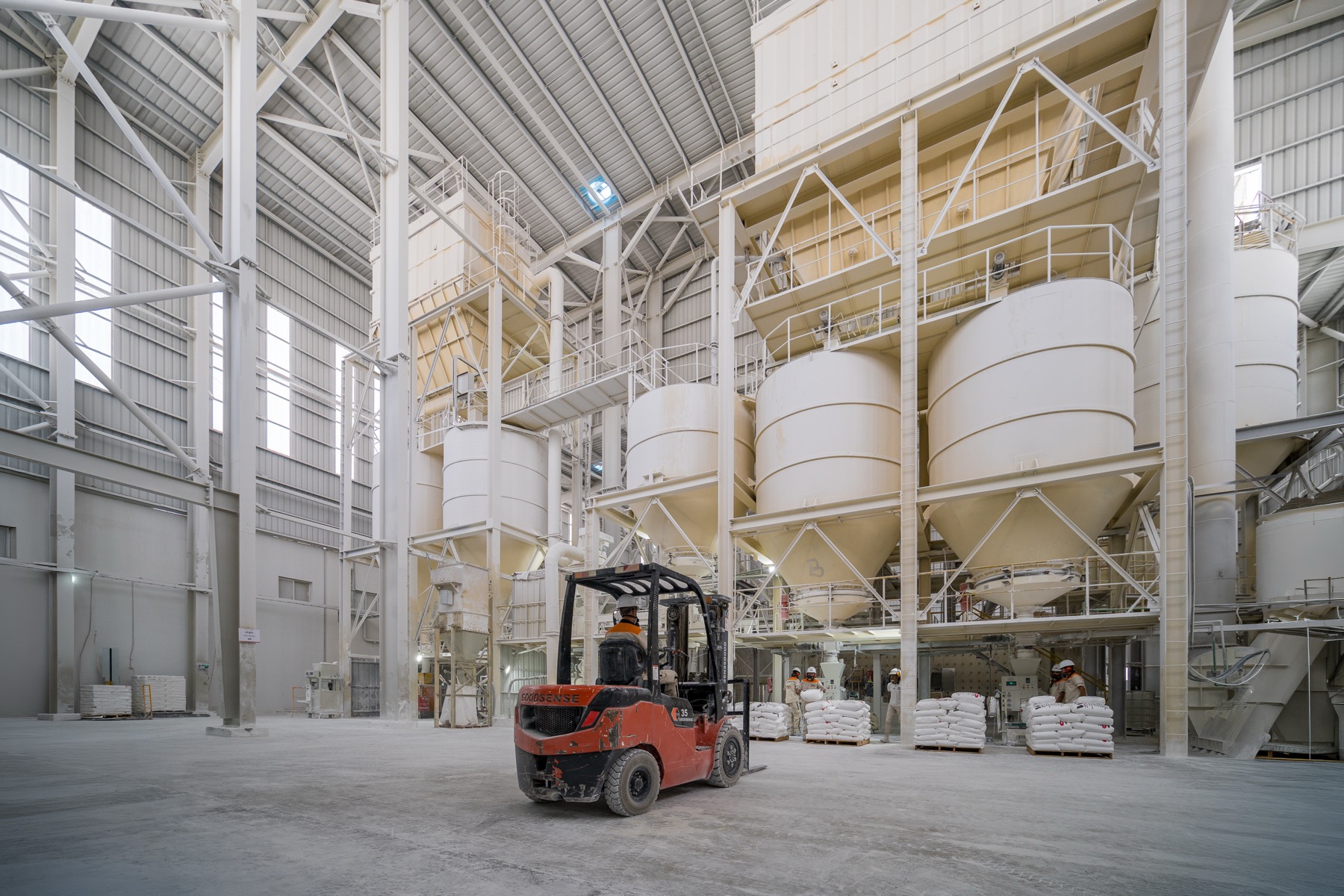 The White Stone production hall — forklift on the floor beneath the product silos and packing stations
